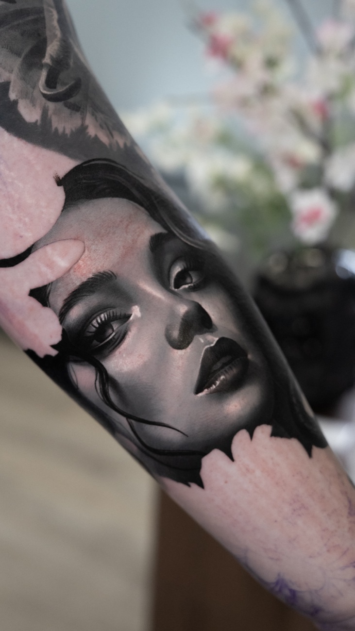 Realism portrait of a woman's face on an arm